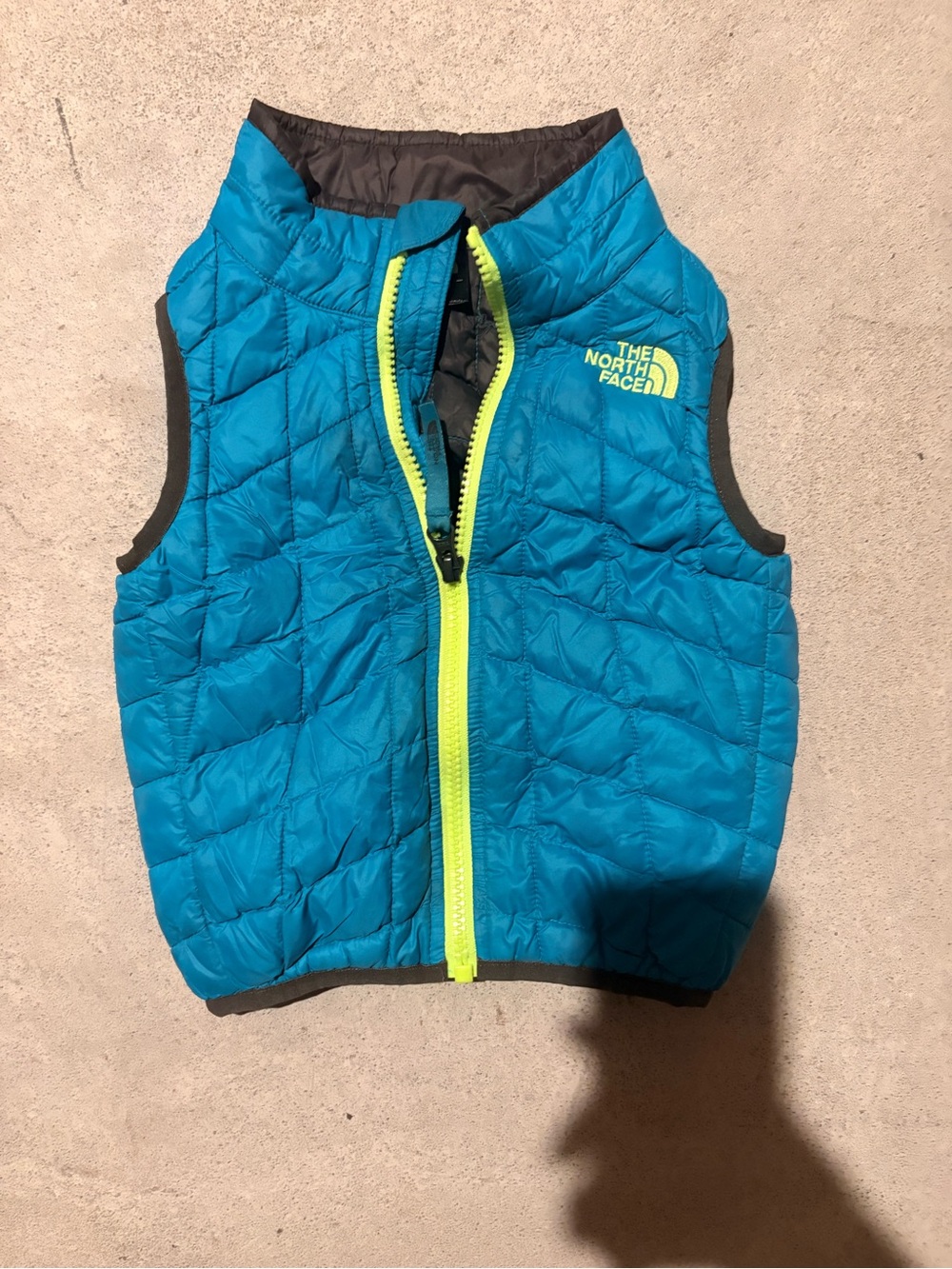 The North Face Kids Blue Puffer Vest with Neon Zipper